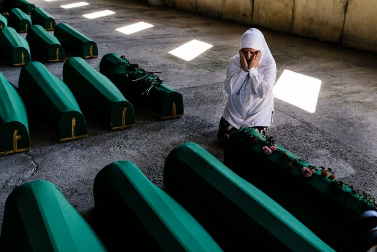 A Bosnian woman mourns next to the coffin of a relative among 136 newly identified victims of the 1995 Srebrenica massacre at the Potocari Memorial Center near the eastern Bosnian town of Srebrenica