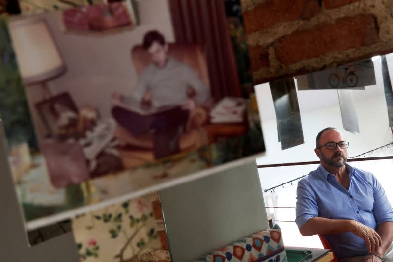 Fernando García-Salmones, de 62 años, posa en su casa junto a una foto suya a la edad en que dice que fue violado por un sacerdote de su escuela en Madrid, España