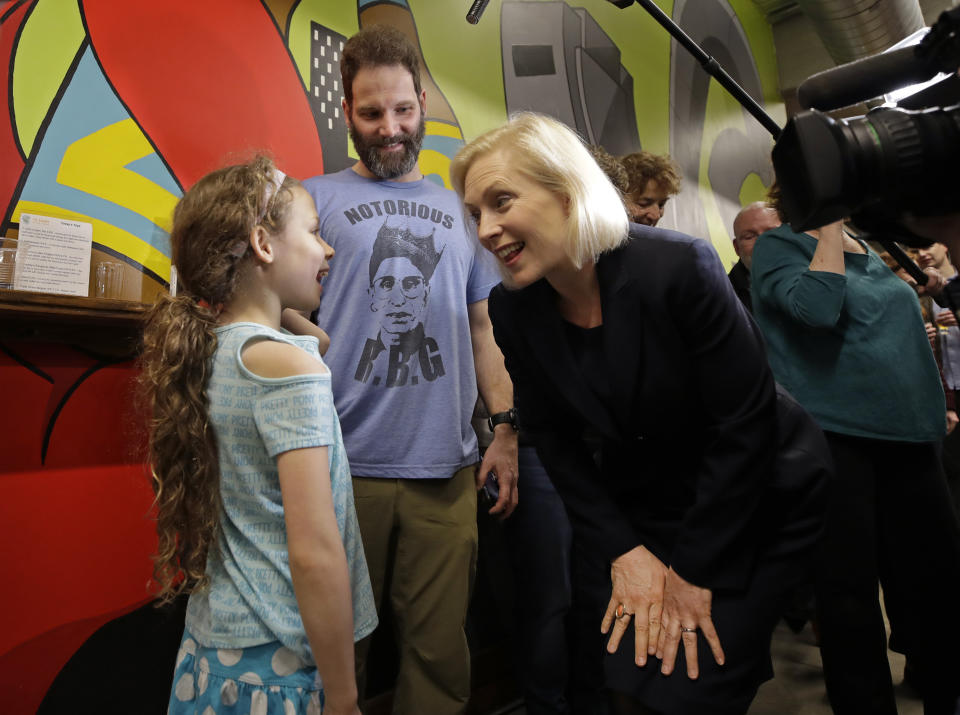 James Porter, of Manchester, N.H., smiles as Democratic presidential candidate Sen. Kirsten Gillibrand, D-N.Y., chats with his 8-year-old daughter, Alice during a campaign meet-and-greet, Friday, March 15, 2019, at To Share Brewing in Manchester, N.H. (AP Photo/Elise Amendola)