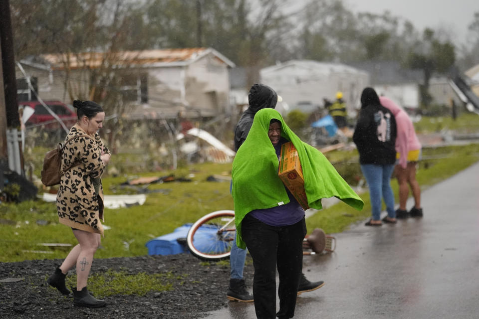 Allyson Mitchell walks in the rain after she arrived to help her niece whose home was destroyed from a tornado that tore through the area in Killona, La., about 30 miles west of New Orleans in St. James Parish, Wednesday, Dec. 14, 2022. (AP Photo/Gerald Herbert)
