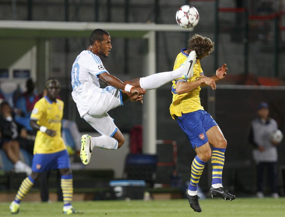 Arsenal's Mathieu Flamini challenges Olympique Marseille's Alaixys Romao during their Group F Champions League soccer match at the Velodrome stadium in Marseille, September 18, 2013. REUTERS/Philippe Laurenson (FRANCE - Tags: SPORT SOCCER)