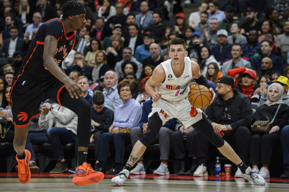 Miami Heat guard Tyler Herro (14) looks to the net while defended by Toronto Raptors forward Chris Boucher (25) during the second half of an NBA basketball game in Toronto on Tuesday, March 28, 2023. (Christopher Katsarov/The Canadian Press via AP)