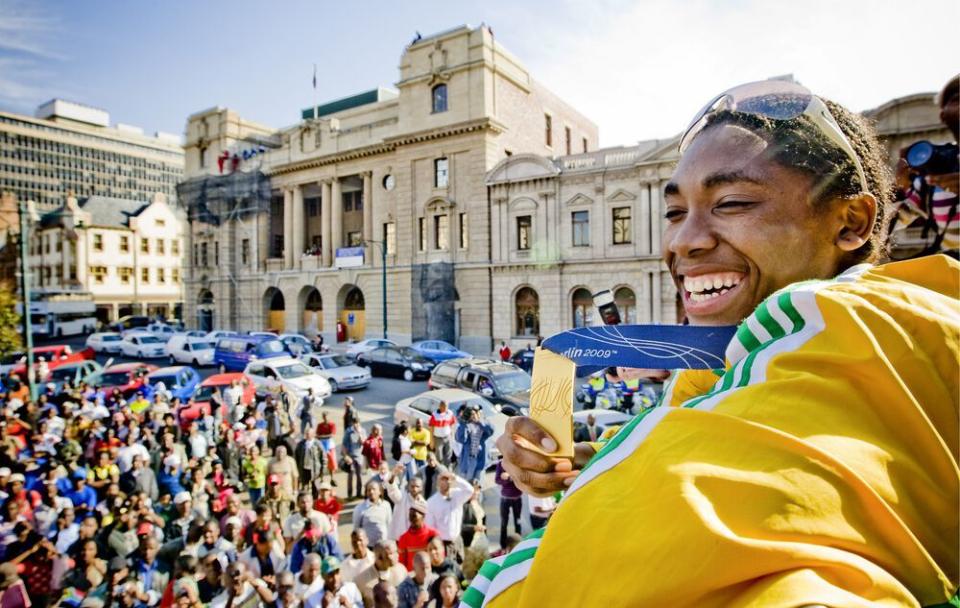 a person holding ice cream cones in front of a crowd of people