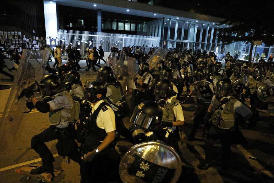 Police officers in anti-riot gear clear protesters from the Legislative Council in Hong Kong, during the early hours of Tuesday, July 2, 2019. Hundreds of protesters in Hong Kong swarmed into the legislature's main building Monday night, tearing down portraits of legislative leaders and spray-painting pro-democracy slogans on the walls of the main chamber as frustration over a lack of response from the administration to opposition demands boiled over. (AP Photo/Vincent Yu)