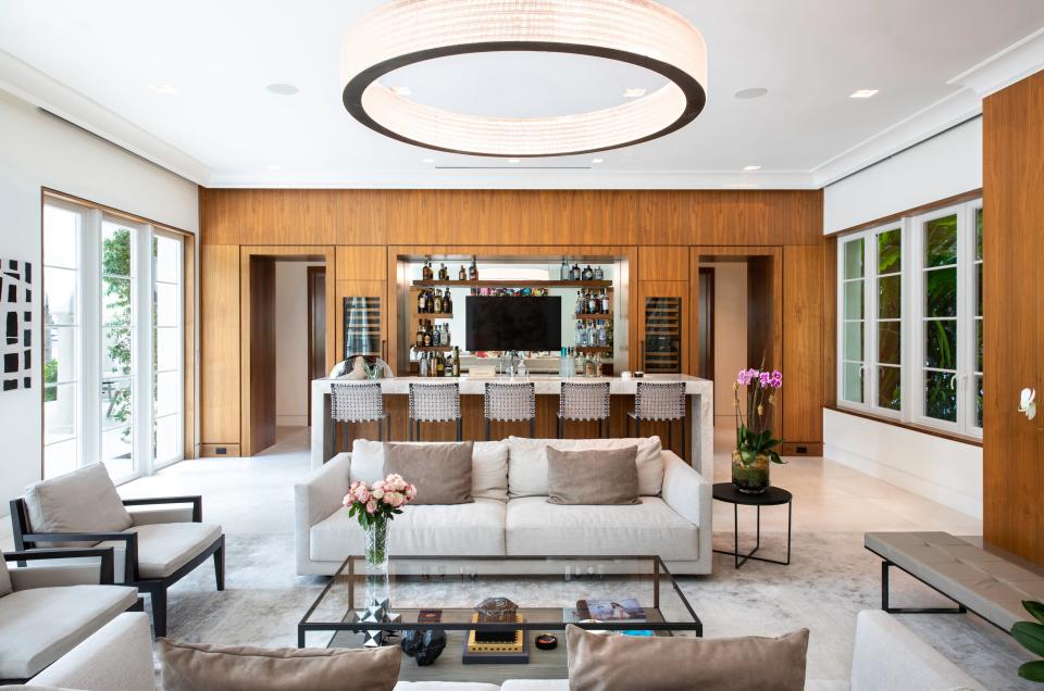 For this tropical modern home, Dunagan Diverio Design Group used warm woods, liquid metal finishes, and limestone flooring to contrast against the white cabinetry and stylish appliances, creating a welcoming kitchen.