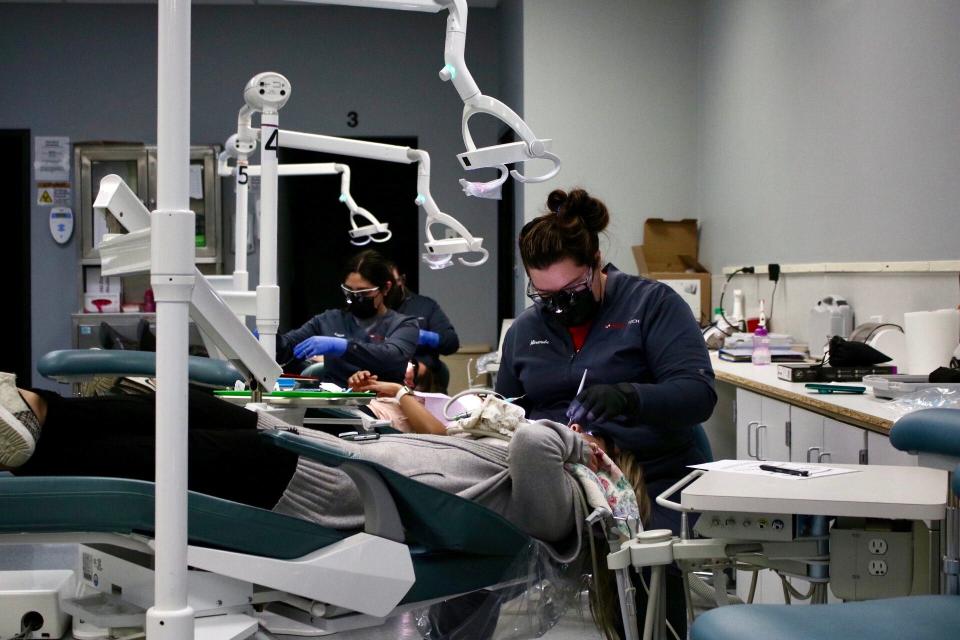Liliana Montes (left) and Miranda Krueger (right) work on patient cleanings Dec. 12. Montes and Krueger are both first-year students in the dental hygiene program.