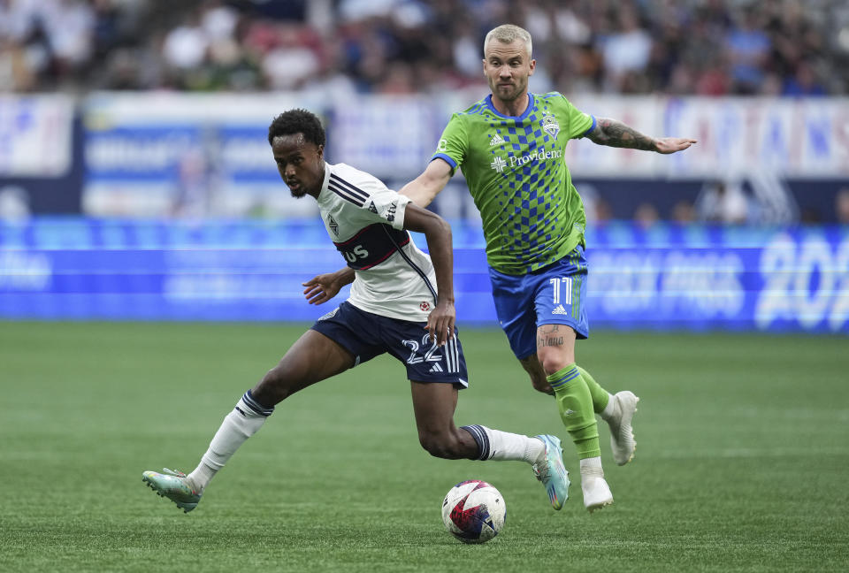 Vancouver Whitecaps' Ali Ahmed (22) and Seattle Sounders' Albert Rusnak (11) vie for the ball during the first half of an MLS soccer match in Vancouver, British Columbia on Saturday, May 20, 2023. (Darryl Dyck/The Canadian Press via AP)