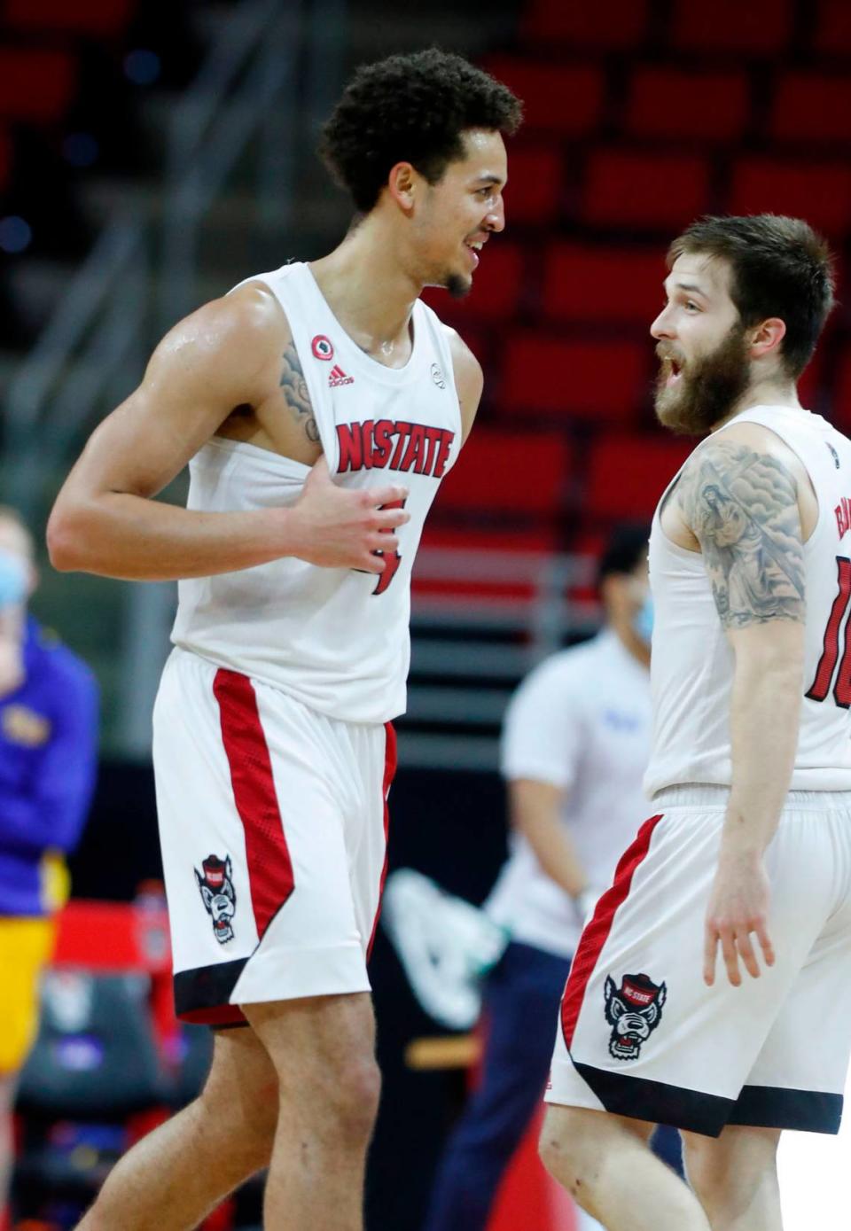 N.C. State’s Jericole Hellems (4) celebrates with Braxton Beverly (10) during the second half of N.C. State’s 65-62 victory over Pittsburgh at PNC Arena in Raleigh, N.C., Sunday, February 28, 2021.