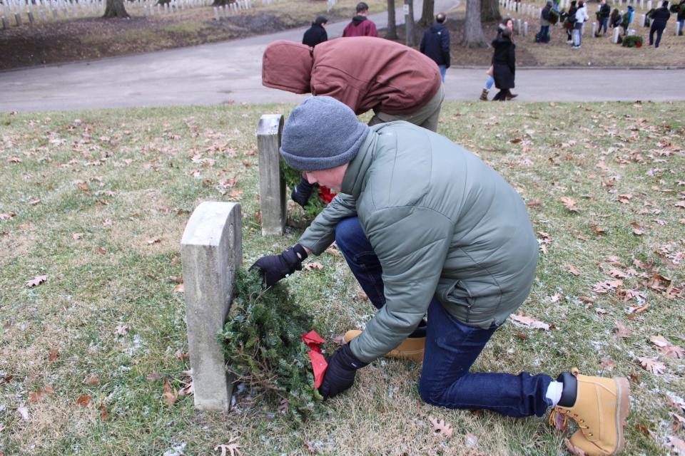 Gabe Rush, kneeling, and Owen Babiak, members of Boy Scout Troop 372 in Lafayette, decorate graves Saturday, Dec. 17, 2022, at the Indiana Veterans Home in West Lafayette. The Christmas decorations are part of Wreaths Across America.