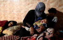 <p>An Iraqi woman sits with her children inside a house in Hawi Al- Josaq after Iraqi forces retook it from Islamic State militants in west Mosul, Iraq February 25, 2017. (Zohra Bensemra/Reuters) </p>