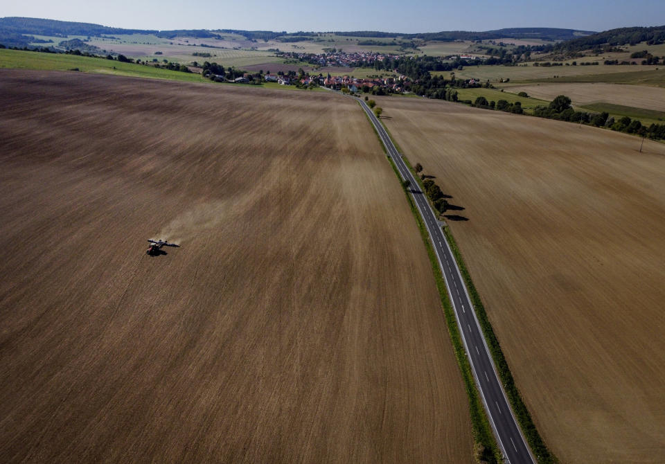 A farmer works on a large acre in the former border area between East and West Germany in Kaltenwestheim, eastern Germany, Monday, Sept. 21, 2020. GThirty years after Germany was reunited on Oct. 3, 1990, many once-decrepit city centers in the formerly communist east have been painstakingly restored and new factories have sprung up. But many companies and facilities didn't survive the abrupt transition to capitalism inefficient companies found themselves struggling to compete in a market economy, while demand for eastern products slumped and outdated facilities were shut down. (AP Photo/Michael Probst)