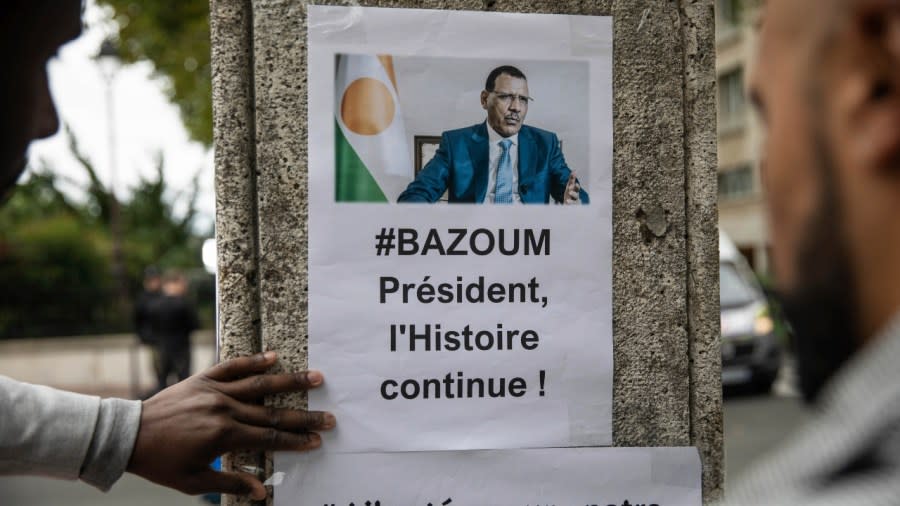 Demonstrators post fliers in front of the Embassy of Niger in Paris Saturday to support deposed Niger President Mohamed Bazoum and ECOWAS. (Photo: Sophie Garcia/AP)