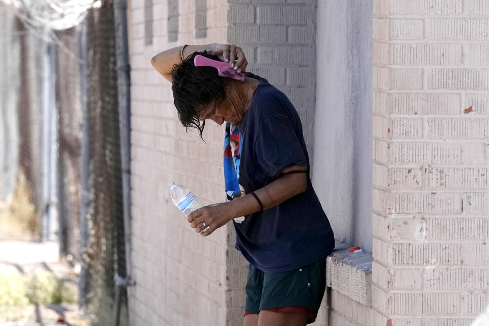 FILE - A person tries to cool off in the shade as temperatures are expected to hit 116-degrees Fahrenheit, Tuesday, July 18, 2023, in Phoenix. Arizona’s health department has named a physician to address ways to lessen the effects of extreme heat in the arid Southwestern state as the first statewide heat officer in the nation. (AP Photo/Ross D. Franklin, File)