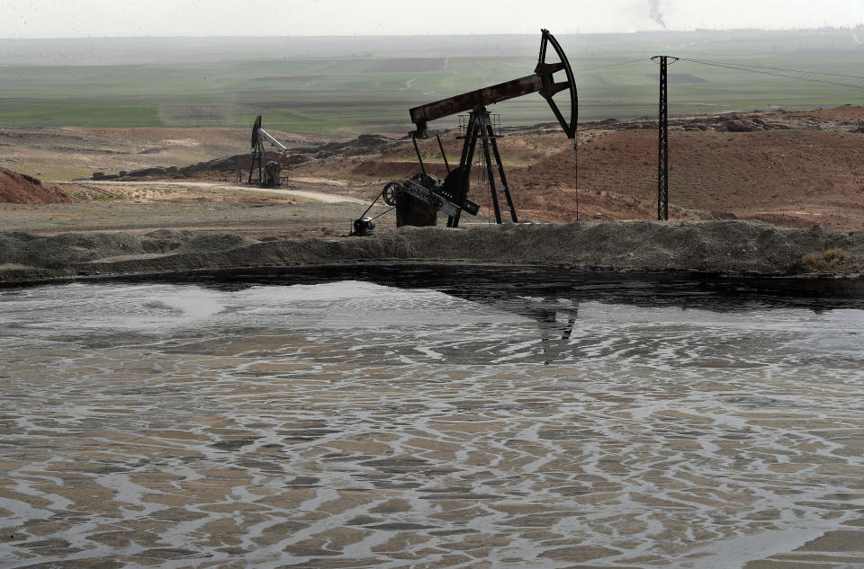 FILE - This March 27, 2018 file photo shows a pond of oil at an oil field controlled by a U.S-backed Kurdish group, in Rmeilan, Hassakeh province, Syria. In Syria nowadays, there is an impending fear that all doors are closing. After nearly a decade of war, the country is crumbling under the weight of years-long western sanctions, government corruption and infighting, a pandemic and an economic downslide made worse by the financial crisis in Lebanon, Syria's main link with the outside world. (AP Photo/Hussein Malla, File)