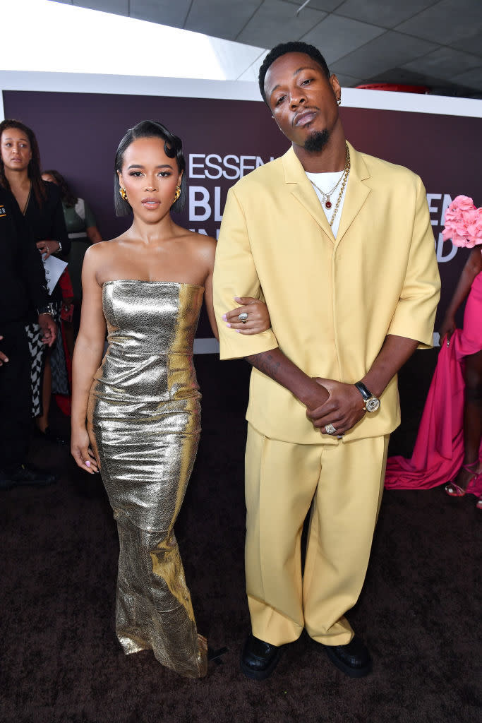Serayah in a metallic strapless gown arm in arm with Joey Bada$$ who is wearing a relaxed-fit suit