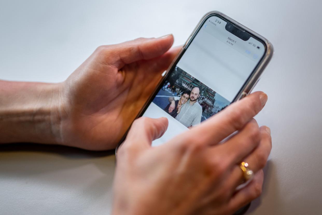 Evgenia Kara-Murza, the wife of Kremlin critic Vladimir Kara-Murza shows a picture of her and her husband on her mobile phone during an interview with AFP on the sidelines of the Geneva Summit for Human Rights and Democracy, in May 2023 (AFP via Getty Images)