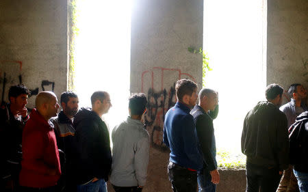 Migrants wait for food inside a dorm destroyed during the Bosnian 1992-1995 war, in Bihac, Bosnia and Herzegovina May 11, 2018. REUTERS/Dado Ruvic