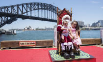 <p>Santa Claus poses for photos with children at Luna Park on December 13, 2017 in Sydney, Australia. Luna Park has pulled some strings in the Northern Hemisphere to host ‘Santa in the Park’ throughout the month of December and up until Christmas Eve families can have their photos taken with the main man with daily appearances with the magical backdrop of the Sydney Harbour Bridge and Opera House. (Photo by James D. Morgan/Getty Images) </p>