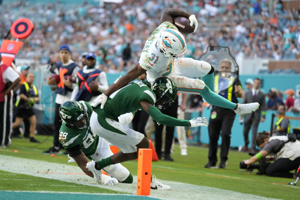 Miami Dolphins running back Raheem Mostert (31) is pushed out of bounds just short of the end zone by New York Jets defensive end Will McDonald IV (99) and cornerback Sauce Gardner (1) during the second half of an NFL football game, Sunday, Dec. 17, 2023, in Miami Gardens, Fla. (AP Photo/Rebecca Blackwell)