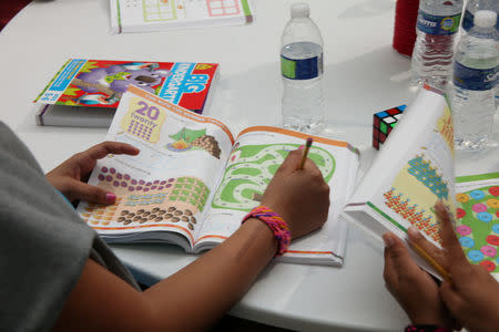 Children working on study guide at a tent city set up to hold immigrant children separated from their parents or who crossed the U.S. border on their own, are seen in Tornillo, Texas, U.S., in this U.S. Department of Health and Human Services (HHS) image released on October 12, 2018. Courtesy HHS/Handout via REUTERS