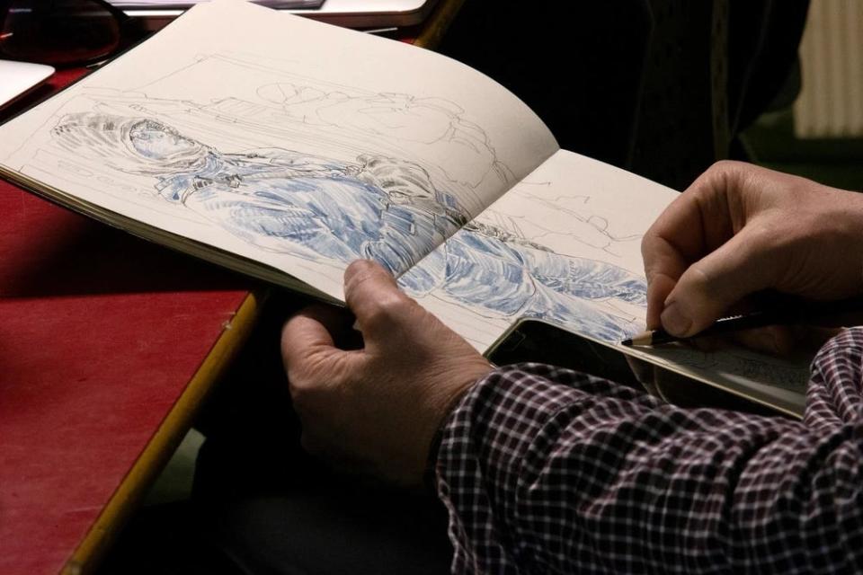 Richard Johnson, a combat artist with the Marine Corps Combat Art Program, finishes a drawing