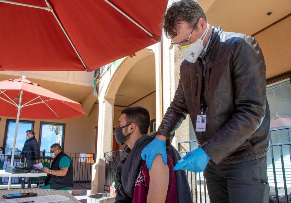 Juan Cardenas, 19, receives the Moderna COVID-19 vaccine from James Hunt, a clinical pharmacist with Terry Reilly Health Services, at the Community Council of Idaho Tuesday, March 23, 2021. Cardenas and his parents received their first doses at the clinic.