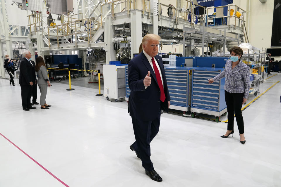 President Donald Trump gestures as he participates in a tour of NASA facilities before viewing the SpaceX Demonstration Mission 2 Launch at Kennedy Space Center, Wednesday, May 27, 2020, in Cape Canaveral, Fla. Marillyn Hewson, chief executive officer of Lockheed Martin, looks on at right. (AP Photo/Evan Vucci)