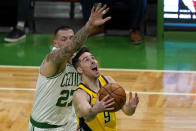 Indiana Pacers guard T.J. McConnell (9) goes to the hoop against Boston Celtics center Daniel Theis (27) in the first quarter of an NBA basketball game, Friday, Feb. 26, 2021, in Boston. (AP Photo/Elise Amendola)