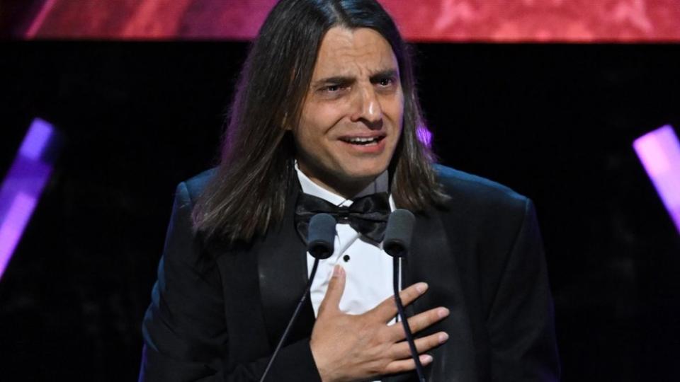 A man looks emotional as he stands at a podium