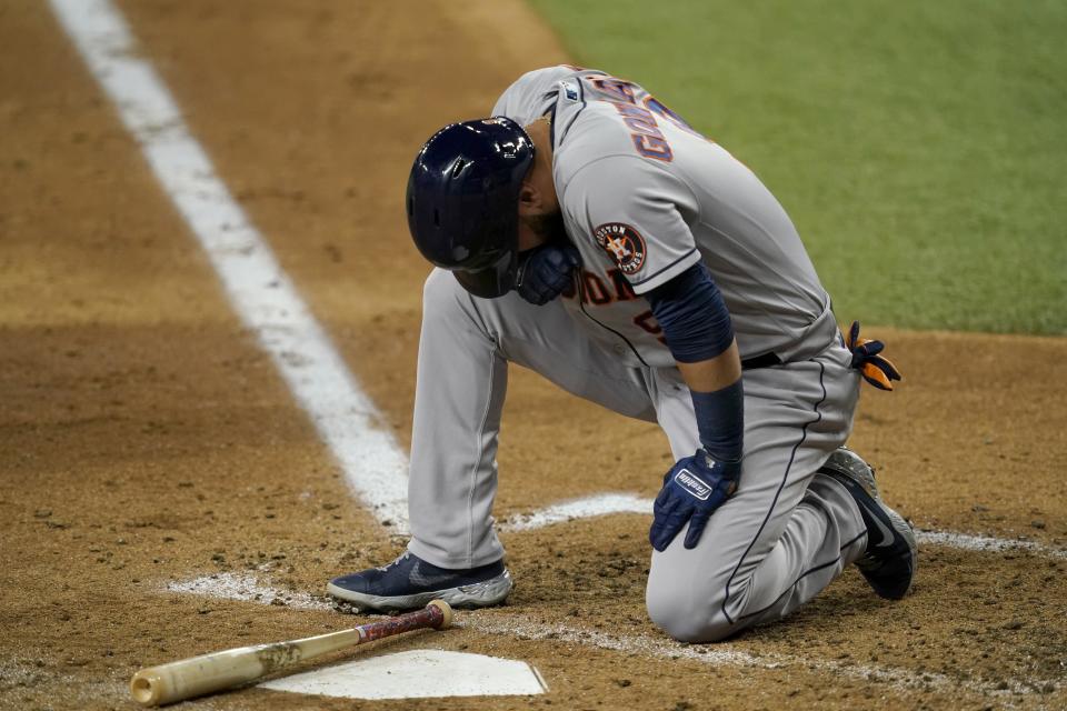 Houston Astros' Marwin Gonzalez kneels by the plate after being hit in the bottom right leg by a pitch thrown by Texas Rangers starter Kohei Arihara in the fourth inning of a baseball game in Arlington, Texas, Wednesday, Sept. 15, 2021. Gonzalez remained in the game. (AP Photo/Tony Gutierrez)