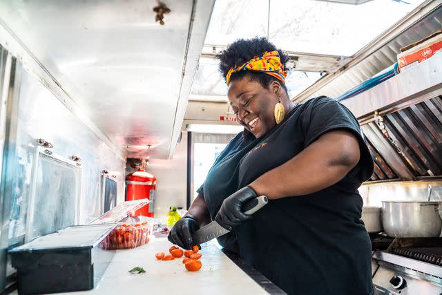 Sabrina Sellers Rheema Calloway chopping tomatoes in the Vegan Hood Chefs food truck.