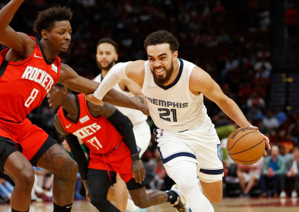 Mar 20, 2022; Houston, Texas, USA; Memphis Grizzlies guard Tyus Jones (21) drives with the ball as Houston Rockets forward Jae'Sean Tate (8) defends during the second quarter at Toyota Center. Mandatory Credit: Troy Taormina-USA TODAY Sports