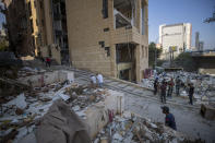 Workers remove debris from destroyed buildings near the site of last week's explosion that hit the seaport of Beirut, Lebanon, Wednesday, Aug. 12, 2020. (AP Photo/Hassan Ammar)
