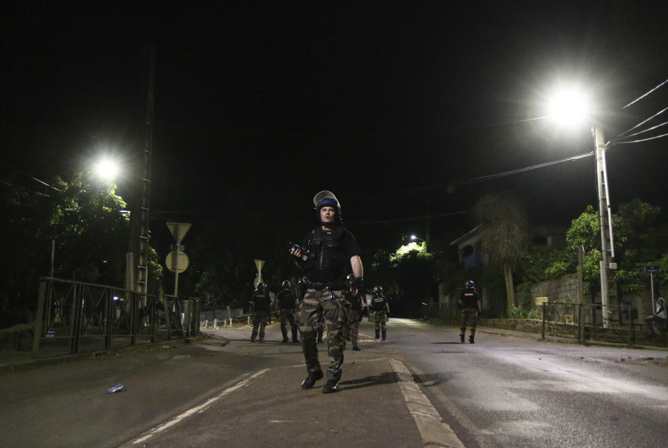 French gendarmes take position in a street of Brandrele as part of the operation "Wuambushu" in the French Indian Ocean territory of Mayotte, Thursday, April 27, 2023. France is facing a migration quagmire on the island territory of Mayotte off Africa’s east coast. The government sent in 2,000 troops and police to carry out mass expulsions, destroy slums and eradicate violent gangs. But the operation has become bogged down and raised concerns of abuse, aggravating tensions between local residents and immigrants from the neighboring country of Comoros. (AP Photo/Gregoire Merot)