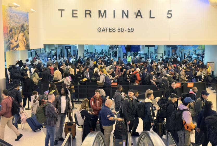 LOS ANGELES CA DECEMBER 21, 2023 — Travelers line-up to go through a TSA check point at Terminal 5 at LAX on Dec. 21.