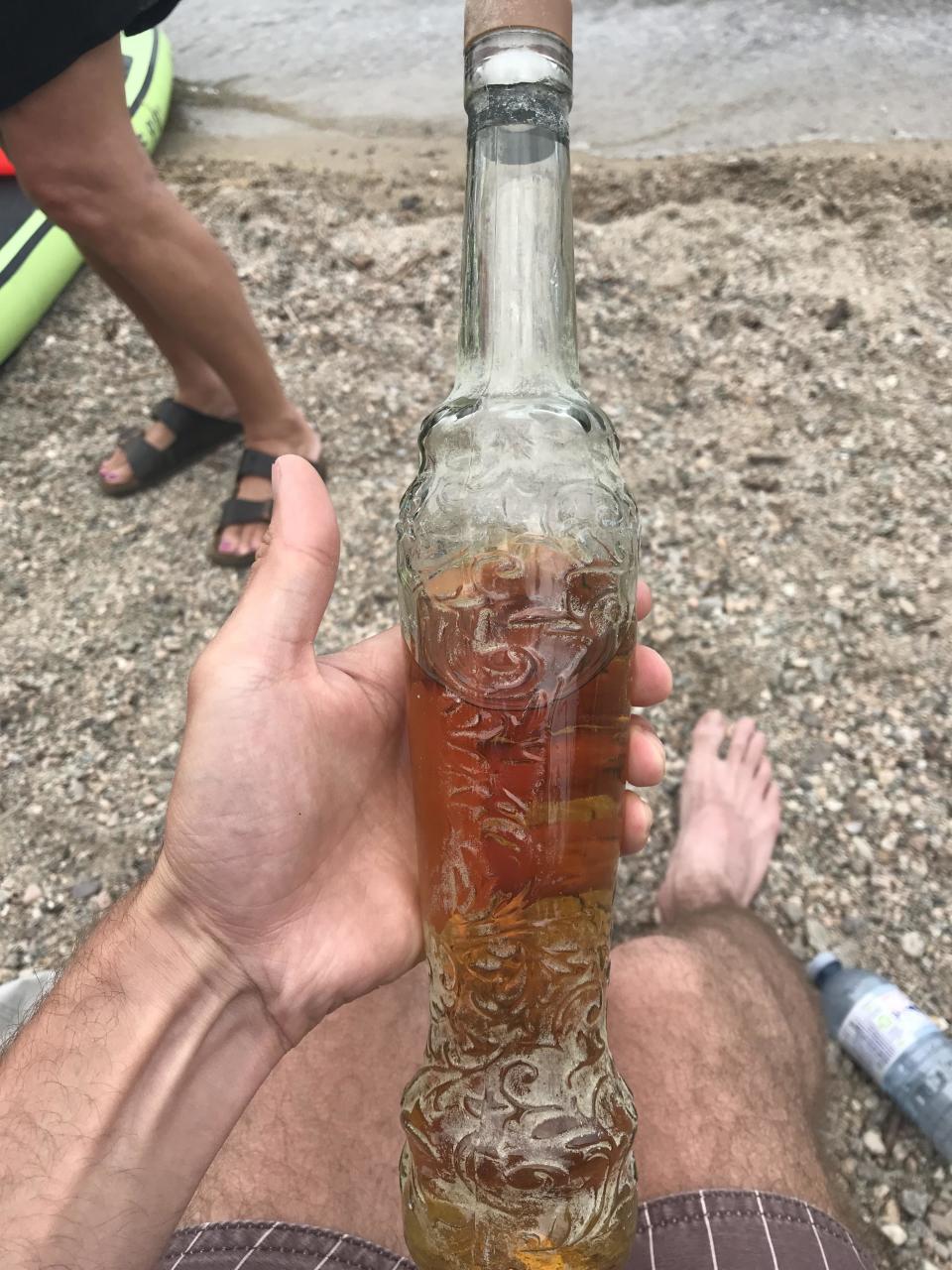 thin, tall, engraved glass bottle with liquid in it