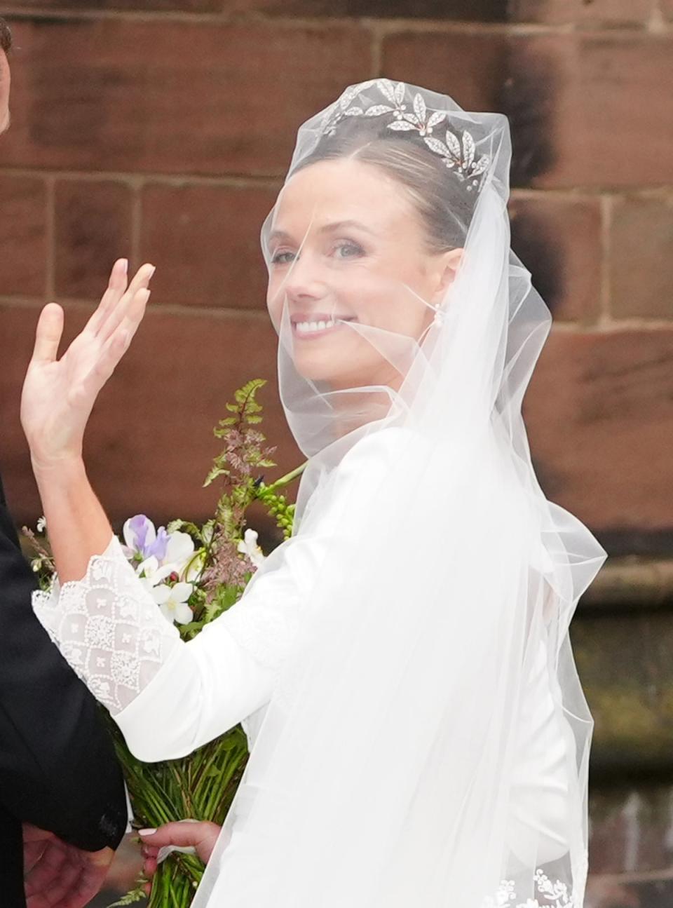 Olivia Henson waves to crowds before entering the cathedral to get married (Peter Byrne/PA Wire)