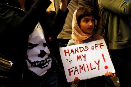 Rosalie Gurna, 9, holds a sign in support of Muslim family members as people protest against U.S. President Donald Trump's travel ban on Muslim majority countries at the International terminal at Los Angeles International Airport (LAX) in Los Angeles, California, U.S., January 28, 2017. REUTERS/Patrick T. Fallon