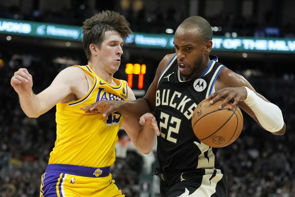 The Bucks' Khris Middleton tries to get past the Lakers' Austin Reaves Tuesday in Milwaukee.