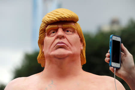 People photograph a naked statue of U.S. Republican presidential nominee Donald Trump that was left in Union Square Park in New York City, U.S. August 18, 2016. REUTERS/Brendan McDermid