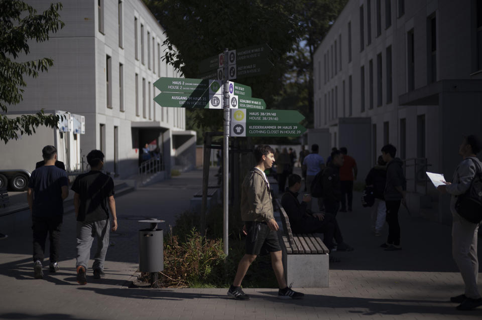 Signs for services in German and English language stand between the buildings of a shelter for temporary accommodation for new asylum seekers near the central registration in Berlin, Germany, Monday, Sept. 25, 2023. Across Germany, officials are sounding the alarm that they are no longer in a position to accommodate migrants who are applying for asylum. (AP Photo/Markus Schreiber)