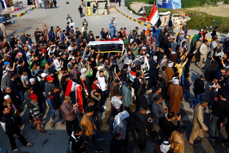 Personas cargan un ataúd durante el funeral de un manifestante que fue asesinado en una protesta contra el gobierno durante la noche en Najaf, Irak