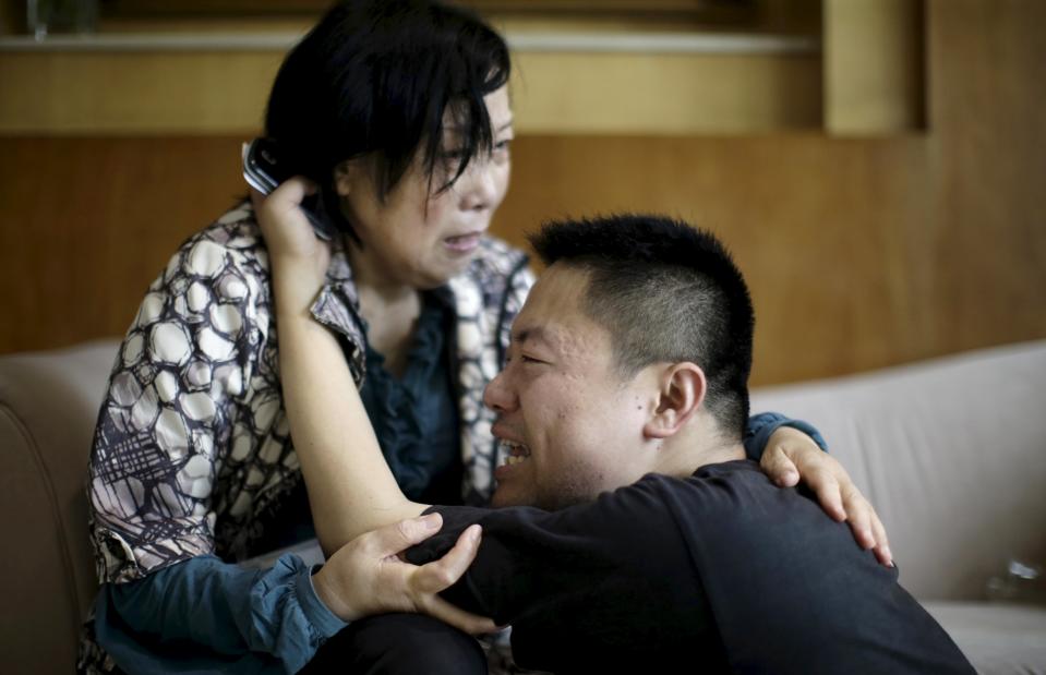 Family members of passengers on the ship which sank at the Jianli section of Yangtze River, in Hubei province, cry outside a closed office of Xiehe Travel in Shanghai, China, June 2, 2015. Divers pulled an 85-year-old woman from the hull of a passenger ship carrying 458 people that capsized on China's Yangtze River and others could still be alive, state media said on Tuesday, in one of China's worst recent disasters. (REUTERS/Stringer)