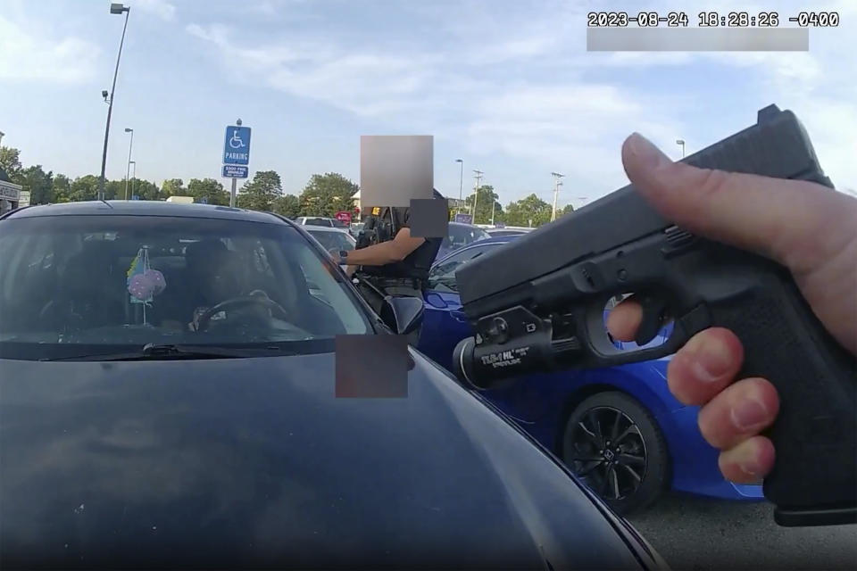 FILE - This image from bodycam video released by the Blendon Township Police on Friday, Sept. 1, 2023, shows an officer pointing his gun at Ta'Kiya Young moments before shooting her through the windshield outside a grocery store in Blendon Township, Ohio, a suburb of Columbus, on Aug. 24. The pregnant Black mother was pronounced dead shortly after the shooting. Her unborn daughter did not survive. The image was pixelated by the source. (Blendon Township Police via AP, File)