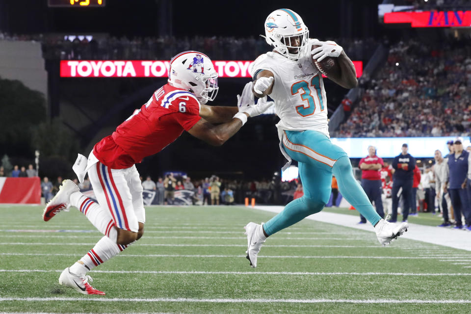 Miami Dolphins running back Raheem Mostert (31) out runs New England Patriots cornerback Christian Gonzalez (6) while stepping over the goal line for a touchdown during the first half of an NFL football game, Sunday, Sept. 17, 2023, in Foxborough, Mass. (AP Photo/Michael Dwyer)