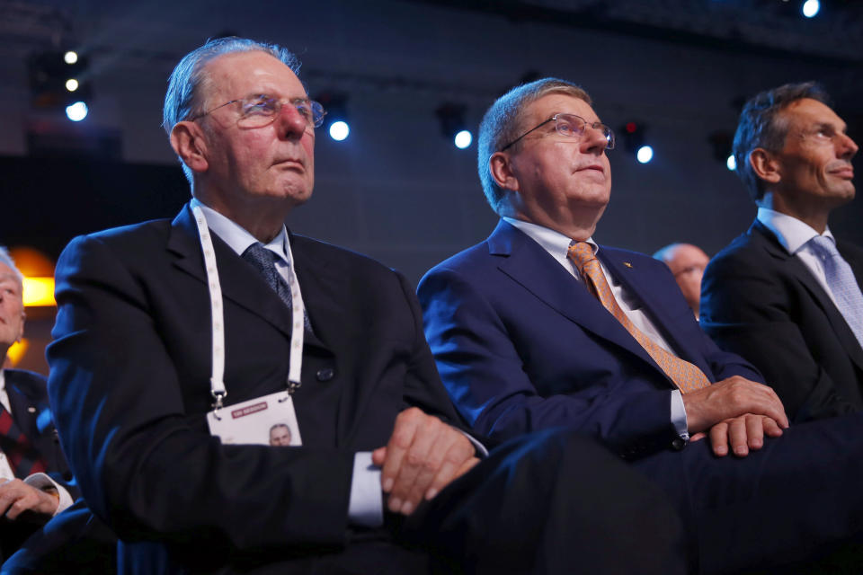 ARCHIVO - En esta foto del viernes 31 de julio de 2015, el presidente honorario del COI Jacques Rogge (izquierda) aparece sentado al lado del presidente en funciones Thomas Bach durante una reunión e Kuala Lumpur, Malasia. Rogge ha fallecido a los 79 años de edad. (AP Foto/Vincent Thian)