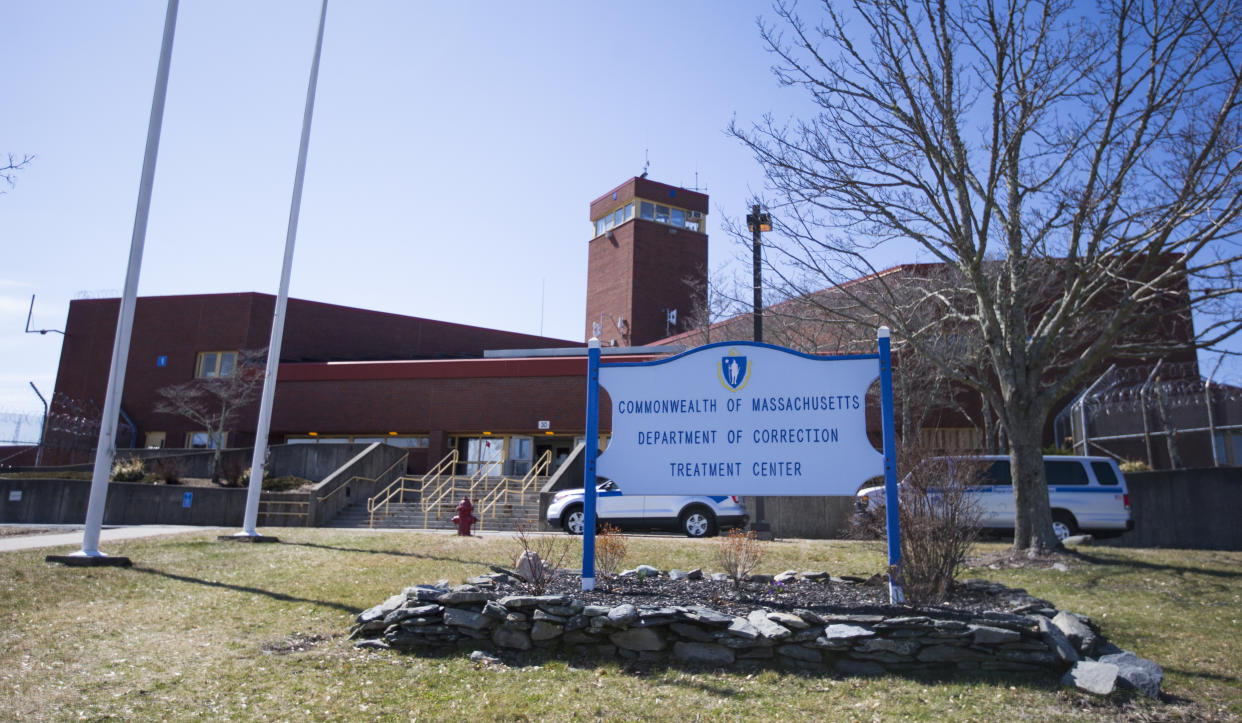 Sign in front of large brick compound surrounded by razor wire reading: Commonwealth of Massachusetts Department of Correction Treatment Center