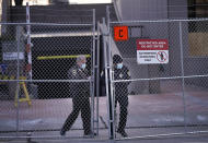 Law enforcement officers open a gate on a fenced perimeter outside the Hennepin County Government Center as preparations continue for the murder trial of former Minneapolis police officer Derek Chauvin which begins Monday and was seen near the Hennepin County Government Center Thursday, March 4, 2021 in Minneapolis. (David Joles/Star Tribune via AP)