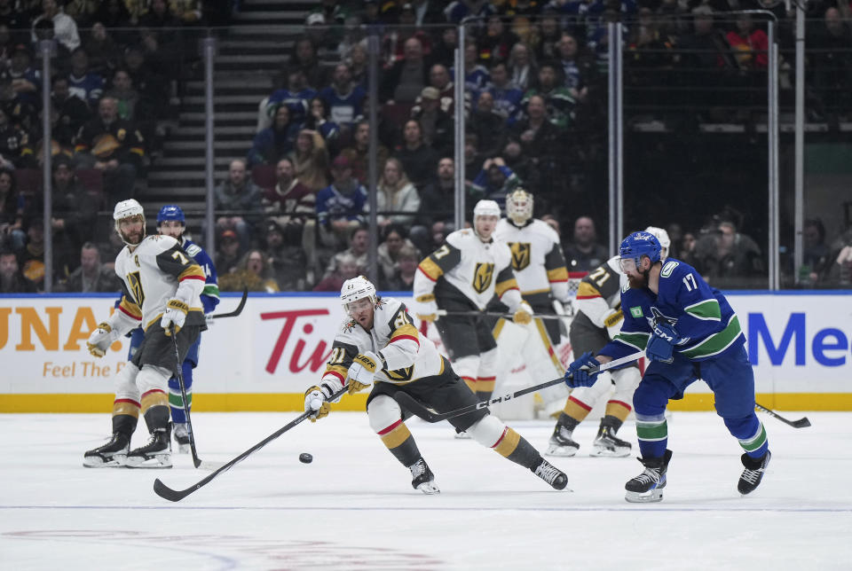 Vegas Golden Knights' Jonathan Marchessault reaches for the puck in front of Vancouver Canucks' Filip Hronek, right, during the second period of an NHL hockey game Thursday, Nov 30, 2023, in Vancouver, British Columbia. (Darryl Dyck/The Canadian Press via AP)