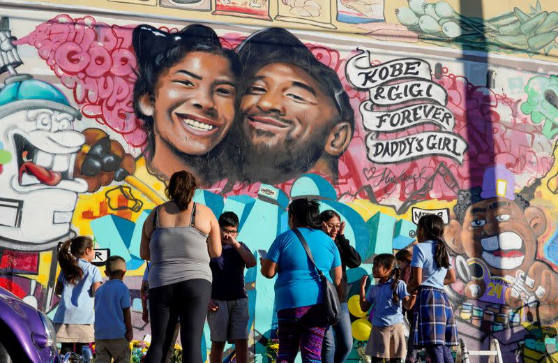 FILE PHOTO: Fans gather around a mural to pay respects to Kobe Bryant after a helicopter crash killed the retired basketball star